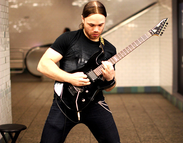 A solo guitarist strums in Times Square.